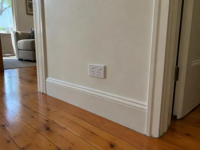 White power point on a painted hallway wall above timber floorboards in Gordon