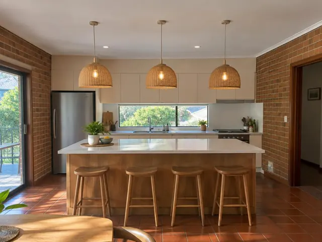 Three woven pendant lights above a kitchen island in a brick-walled home interior in St Ives